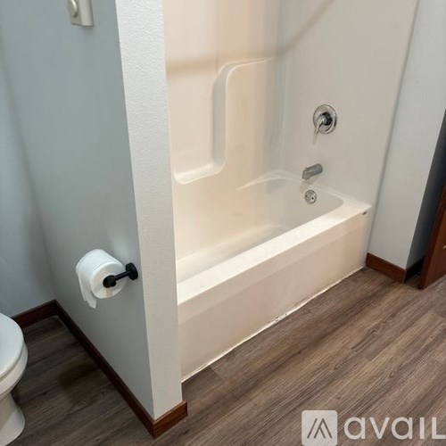 A white bathroom with a toilet and a bathtub.