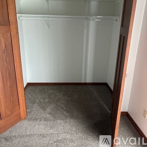 A room with a grey carpet and a white wall.