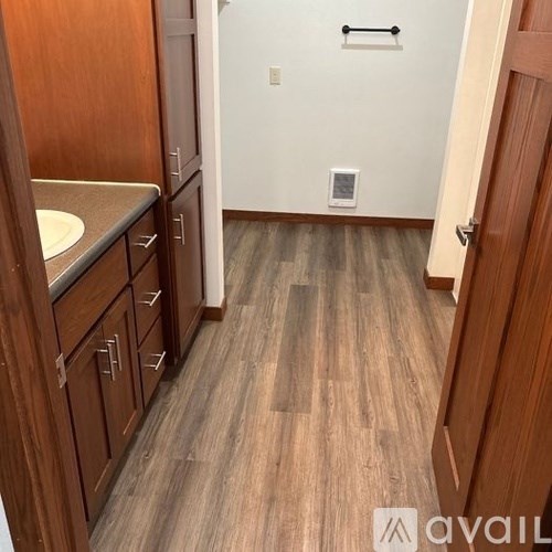 A bathroom with wooden floors and a white sink.