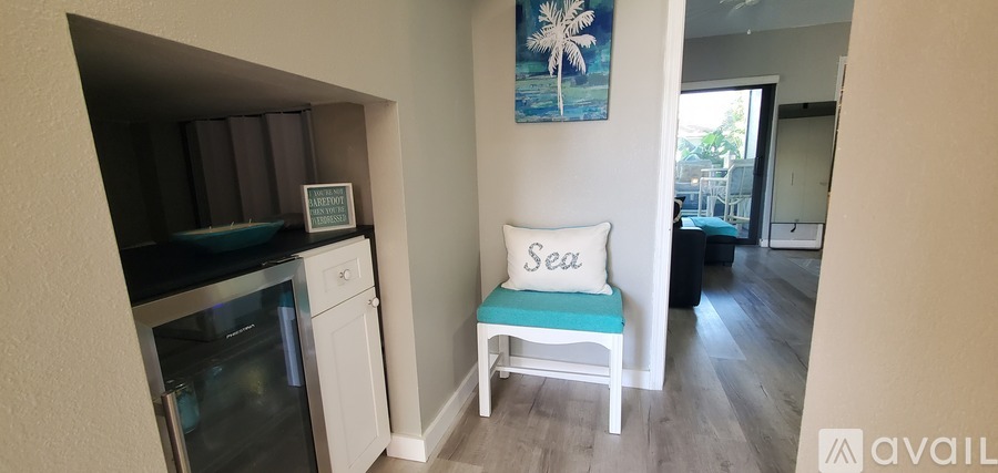 A kitchen with a white oven and a white chair with a blue cushion.