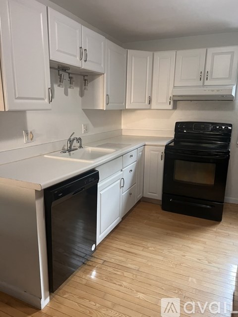 A kitchen with white cabinets and a black oven.