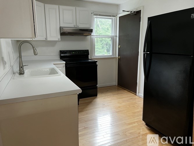 A kitchen with a black fridge and a black oven.