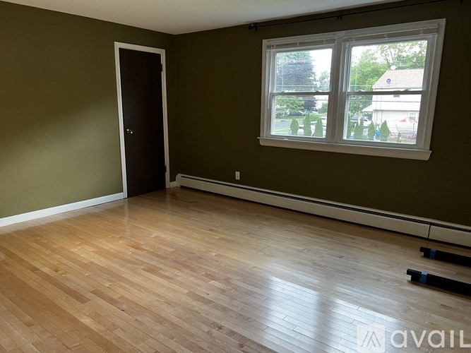 A room with a wooden floor and a window.