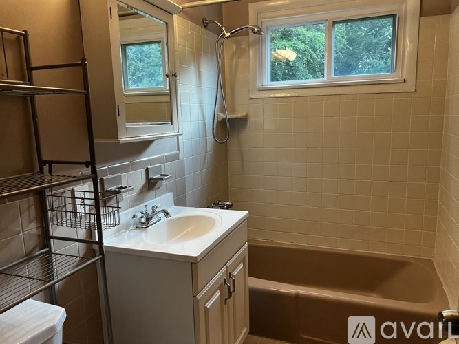 A bathroom with a white sink and a window.