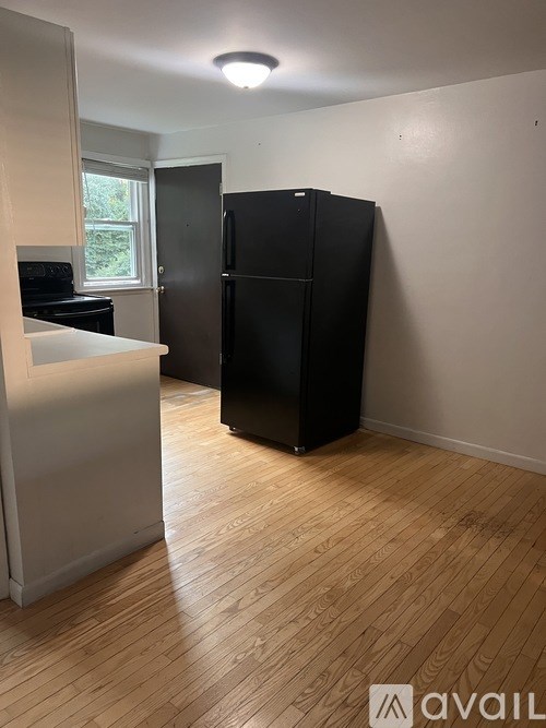 A kitchen with a black fridge and a white counter.