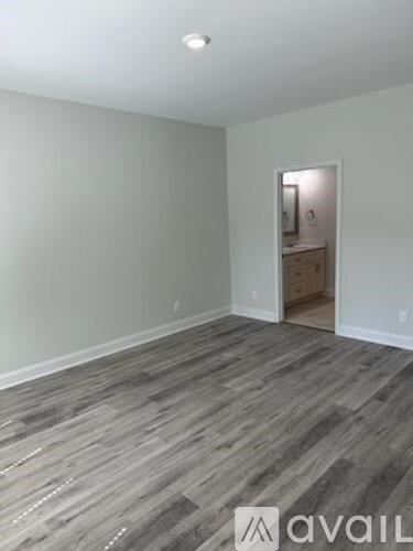 A room with wooden flooring and a white wall.