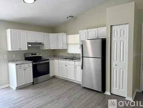 A kitchen with white cabinets and stainless steel appliances.