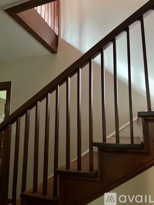 A wooden staircase with a metal railing.