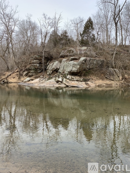 A calm lake surrounded by trees and rocks.