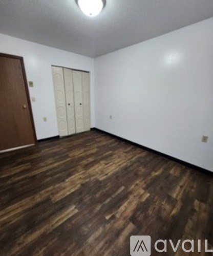 A room with wooden flooring and white walls.