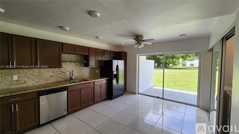 A kitchen with brown cabinets and a marble countertop.