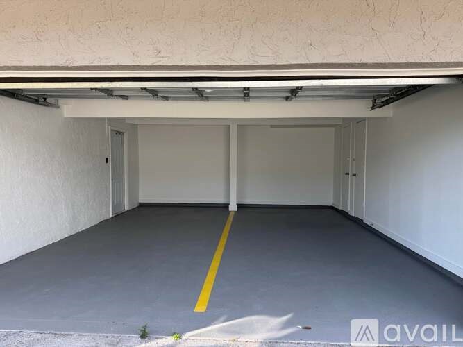 A spacious garage with a yellow line down the middle of the floor.