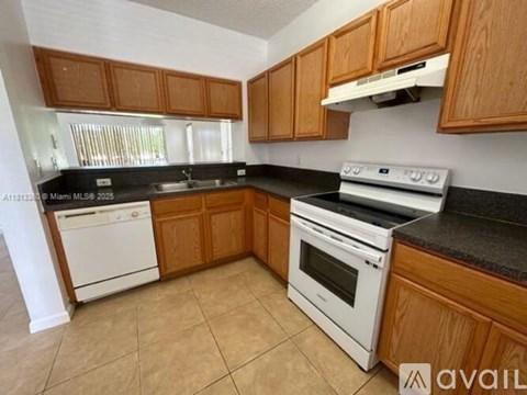 A kitchen with wooden cabinets and white appliances.