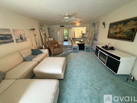 A living room with a white couch and a brown chair.