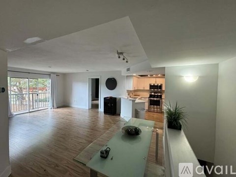 A modern living room with a glass table and a balcony.