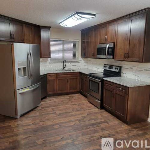 A kitchen with wooden cabinets and a refrigerator.