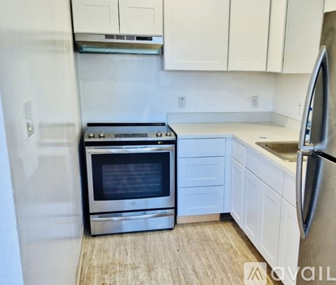 A kitchen with a stove, refrigerator, and cabinets.