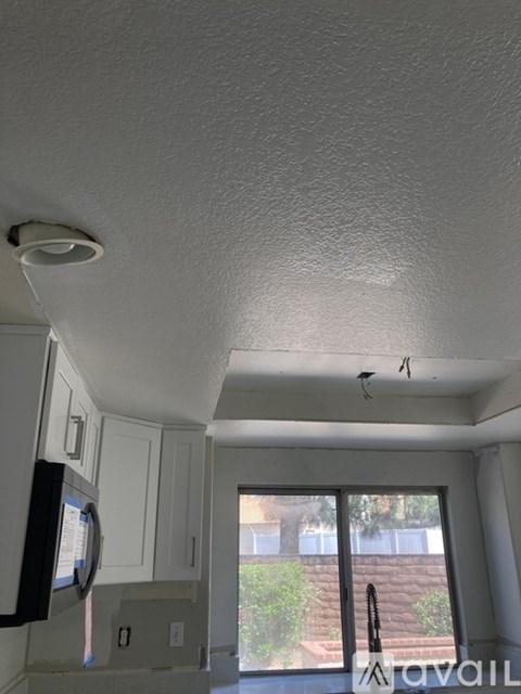 A kitchen with white cabinets and a microwave.
