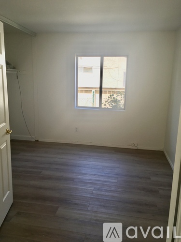 A room with a window and a carpeted floor.