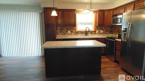 A kitchen with wooden cabinets and a granite countertop.