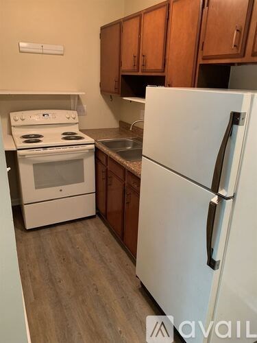 A kitchen with a white fridge and stove top oven.