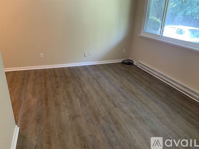A room with wooden flooring and a window.