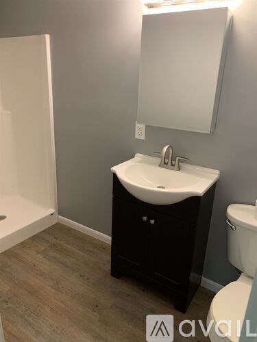 A bathroom with a sink, toilet and mirror.