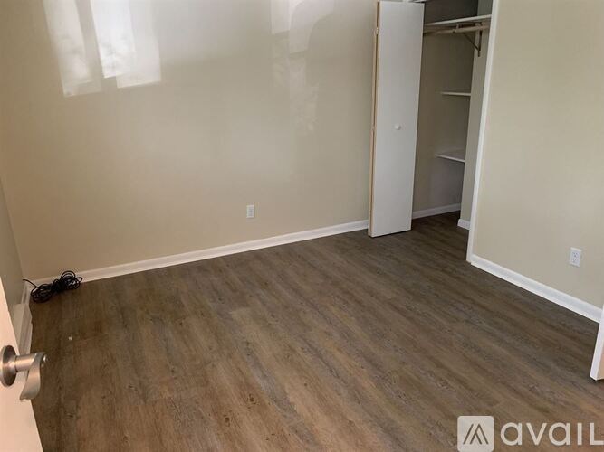 A room with a wooden floor and a white door.