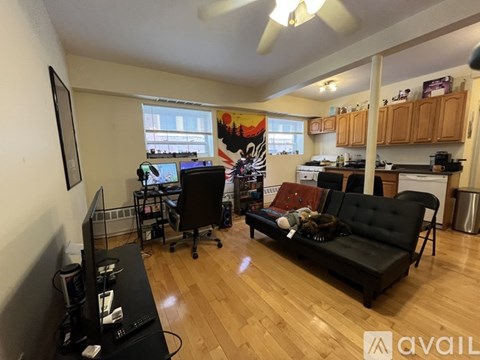 A living room with a black couch and a television.