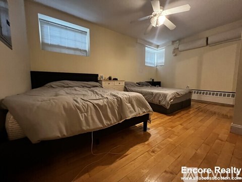 A bedroom with two beds and a ceiling fan.