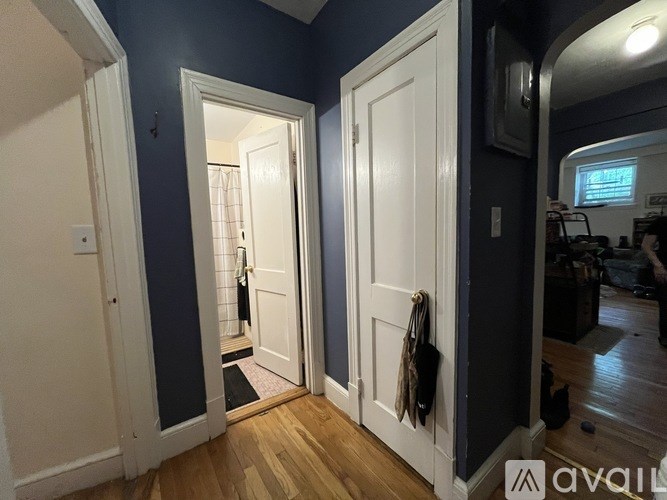 A hallway with two doors and a coat rack.