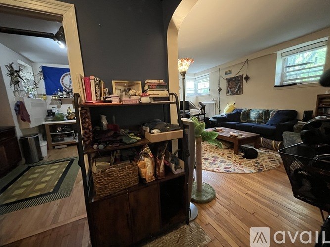 A living room with a couch, a bookshelf, and a rug.
