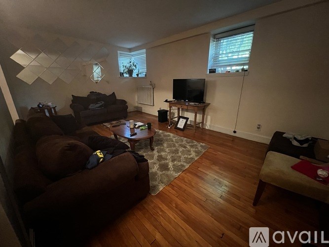 A living room with a brown couch and a television.