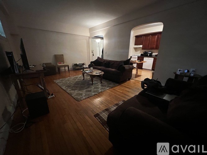 A living room with a couch, chair, and television.