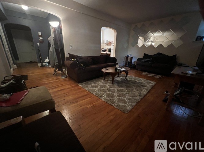 A living room with a couch, a coffee table, and a rug.