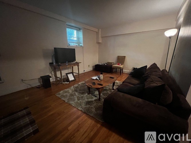 A living room with a brown couch and a television.