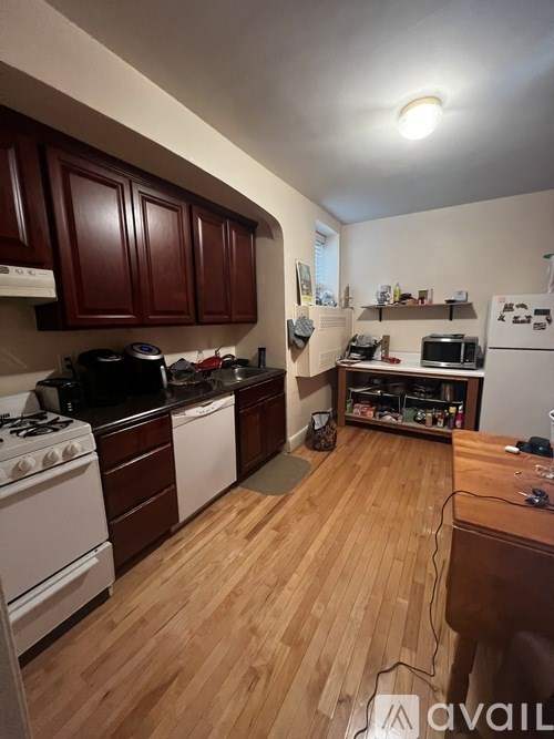 A kitchen with wooden floors and white appliances.