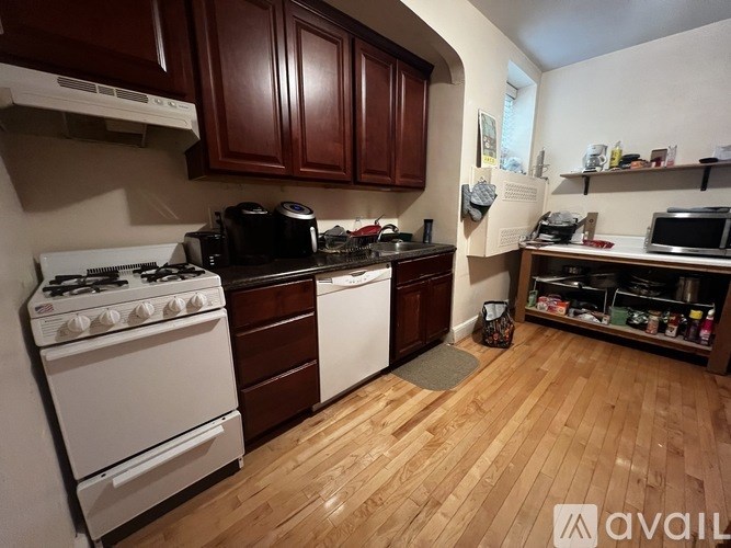 A kitchen with wooden floors and a white stove top oven.