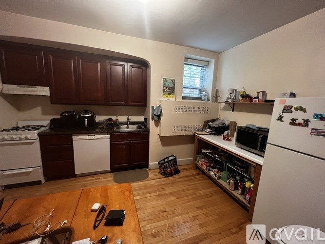 A kitchen with wooden floors and white appliances.