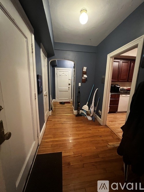 A hallway with a light on and a door at the end.