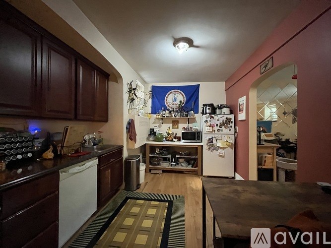 A kitchen with a refrigerator, sink, and cabinets.