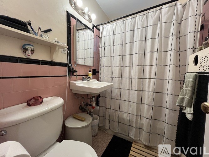 A bathroom with pink walls and a white bathtub.