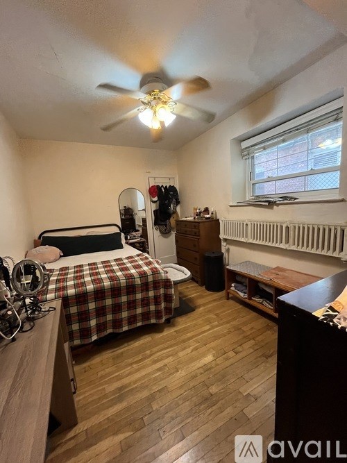 A bedroom with a bed, a dresser, and a window.