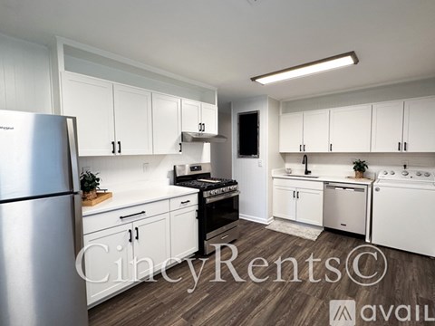 A kitchen with white cabinets and a stainless steel refrigerator.