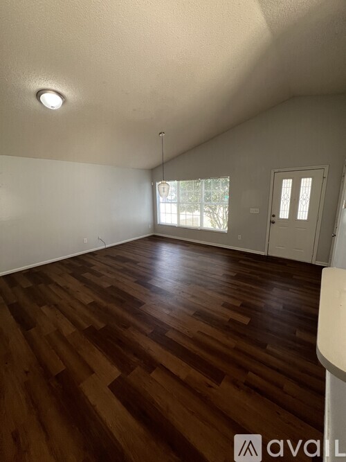 A room with wooden flooring and a white wall.