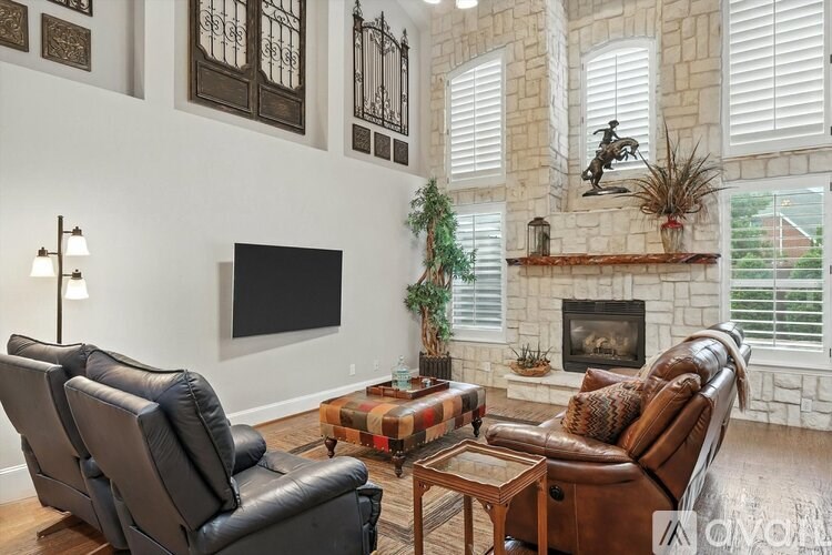 A living room with a fireplace and a flat screen TV.