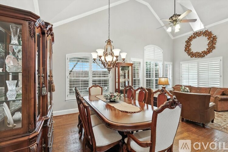 A dining room with a wooden table and chairs.