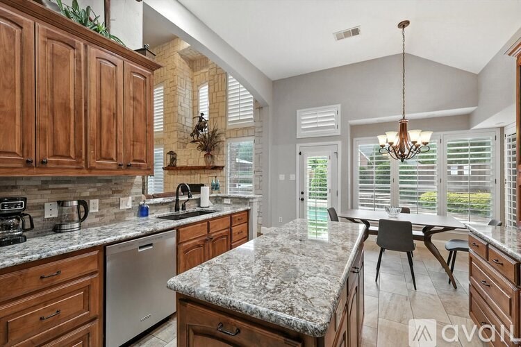 A kitchen with wooden cabinets and granite countertops.