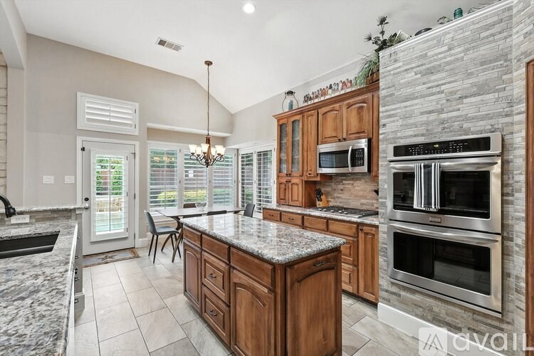 A kitchen with granite countertops and wooden cabinets.