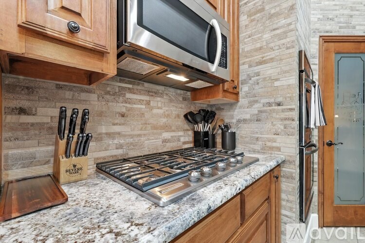 A kitchen with a stove top and a microwave above it.